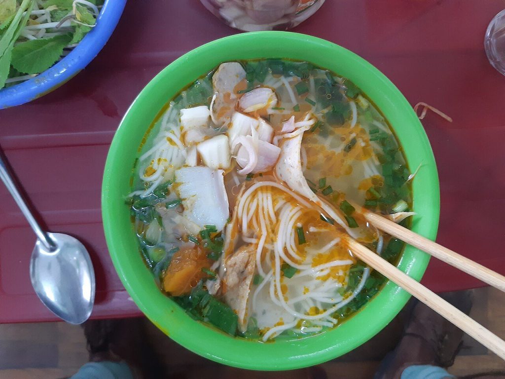 Tô bún chả cá nóng với chả cá và rau thơm